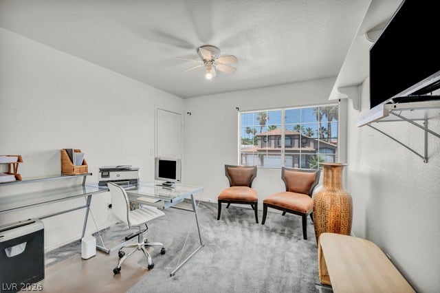 2553 Hummingbird Hill Avenue, Henderson, NV 89074 A well-lit home office features ample desk space and a window view of nearby structures.