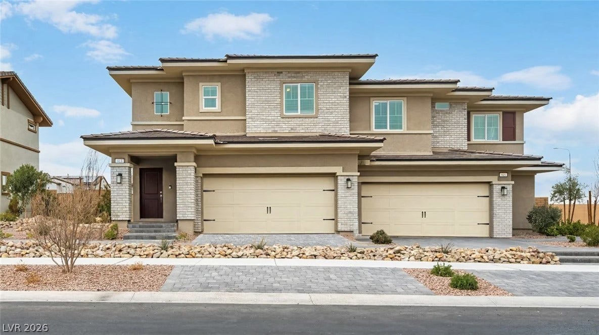 A modern facade with mixed materials, featuring two garages and an inviting entryway.