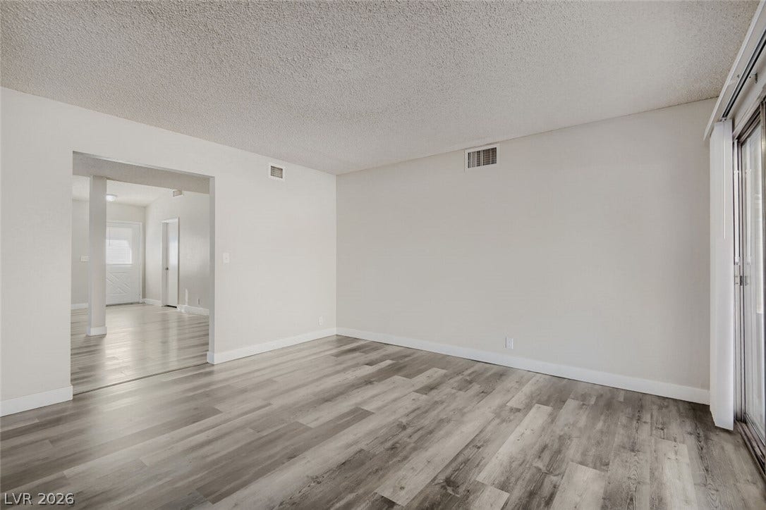 2343 Valleywood Road, Henderson, NV 89014 The generously sized living area boasts contemporary wood flooring and abundant light from sliding glass doors.