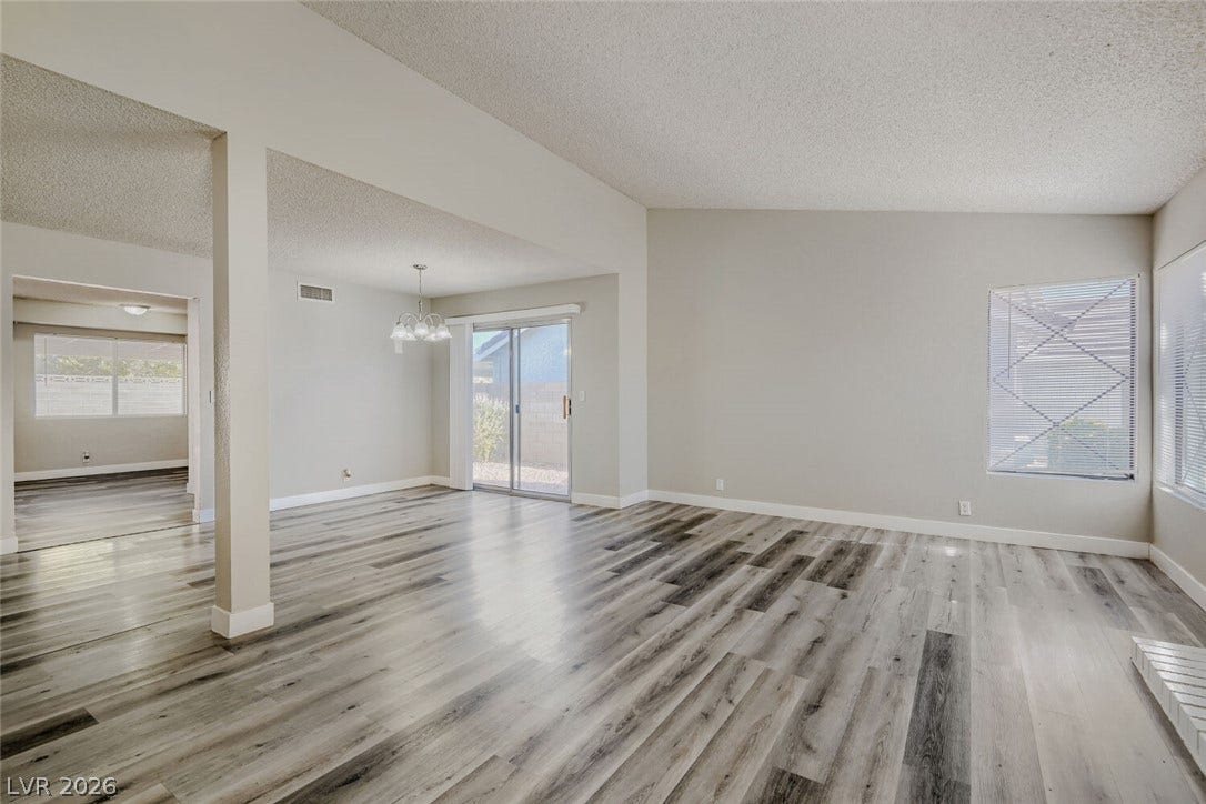 2343 Valleywood Road, Henderson, NV 89014 Natural light floods through multiple windows, illuminating the durable plank flooring throughout this inviting living space.