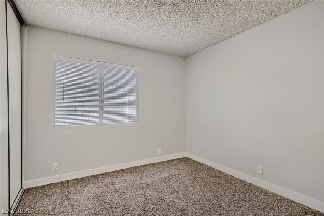 2343 Valleywood Road, Henderson, NV 89014 A well-lit bedroom provides a cozy retreat with soft carpeting and functional window blinds.