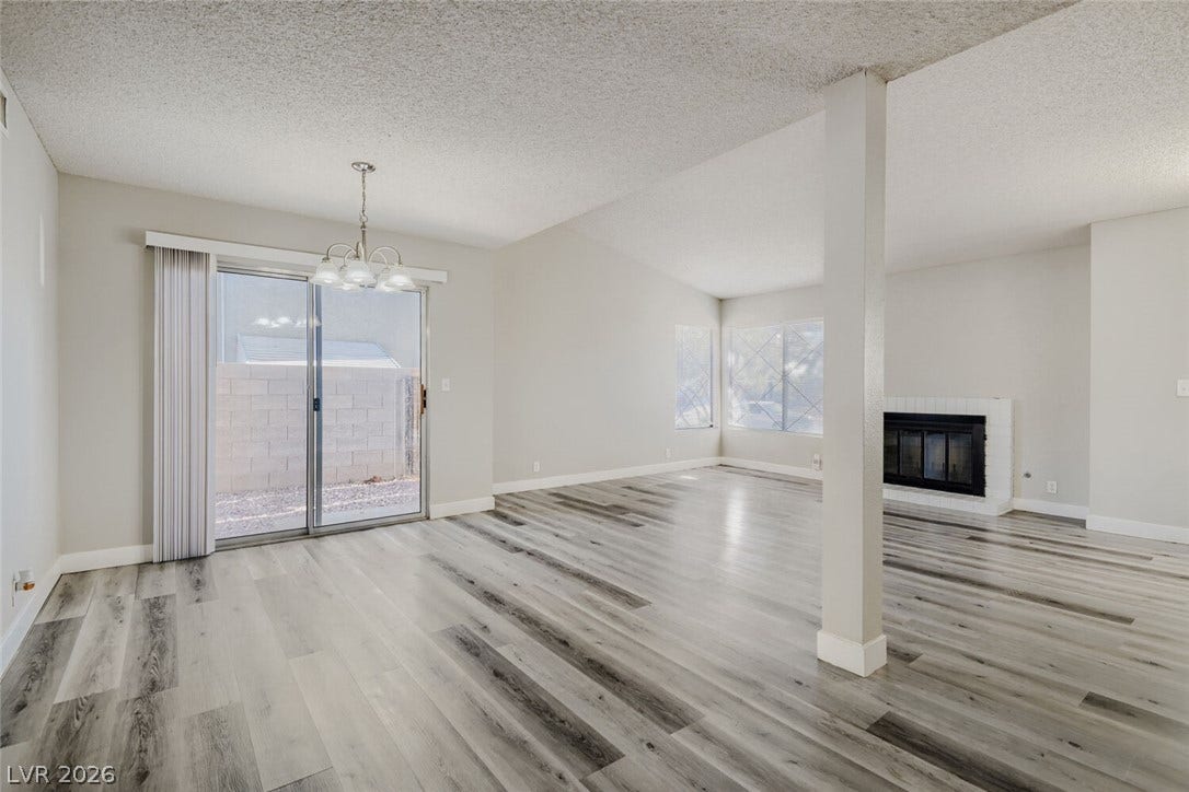 2343 Valleywood Road, Henderson, NV 89014 Laminated flooring stretches throughout this open-plan living and dining area, complete with a cozy fireplace.