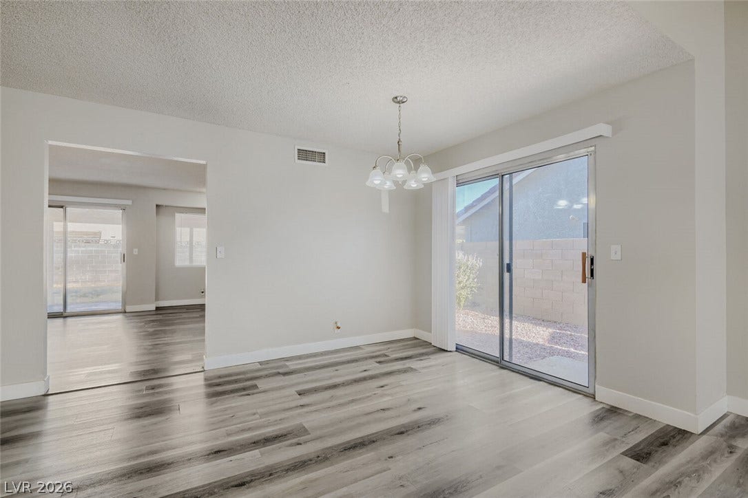 2343 Valleywood Road, Henderson, NV 89014 Sliding glass doors open to a private outdoor space, complementing the wood-style flooring.