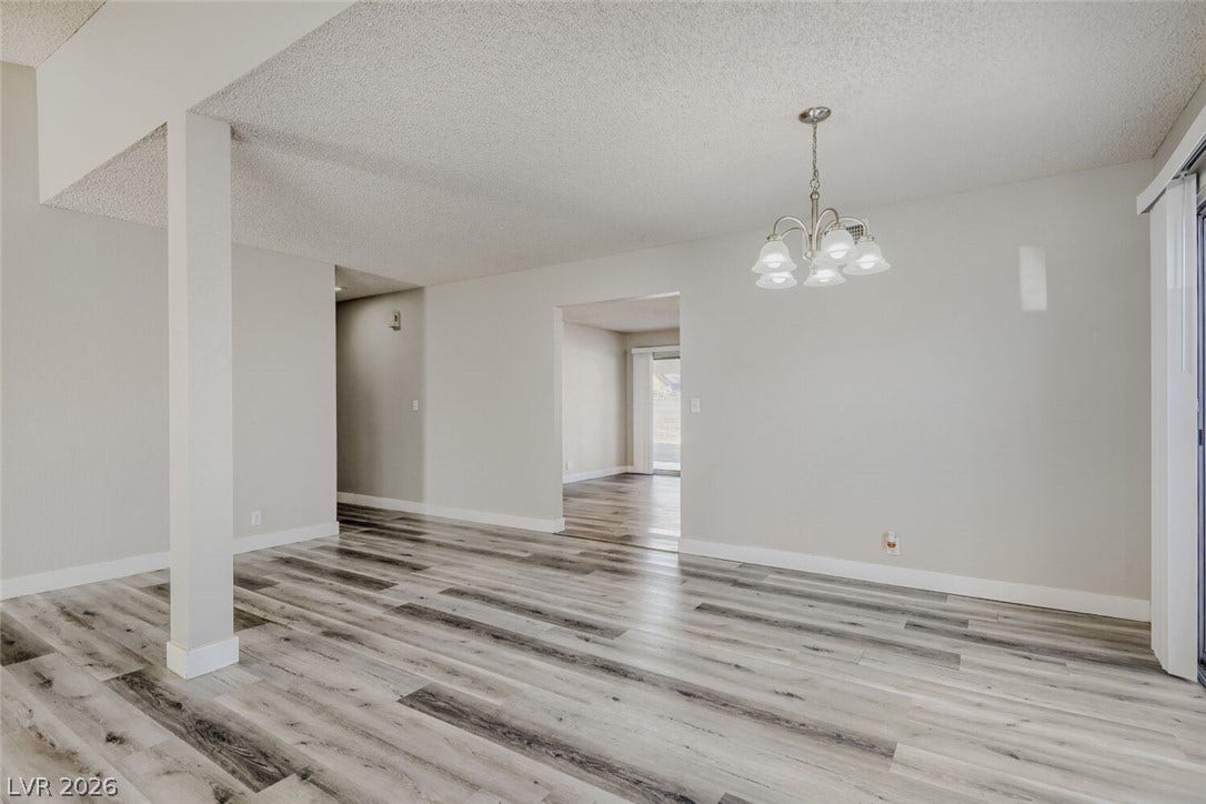 2343 Valleywood Road, Henderson, NV 89014 Newly updated, this adaptable living area boasts stylish laminate flooring and a charming chandelier, ready for your personal touch.