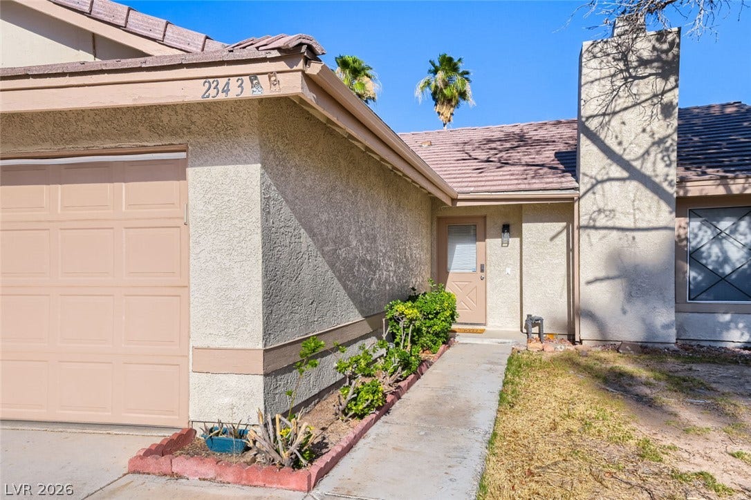 2343 Valleywood Road, Henderson, NV 89014 A classic stucco home with an attached garage and a neatly maintained walkway.