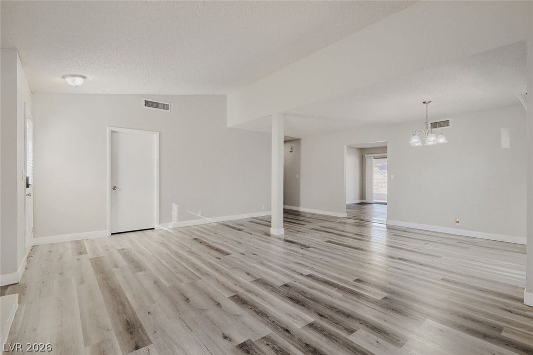2343 Valleywood Road, Henderson, NV 89014 The open-concept living area features wide plank flooring and abundant natural illumination, creating an inviting atmosphere.