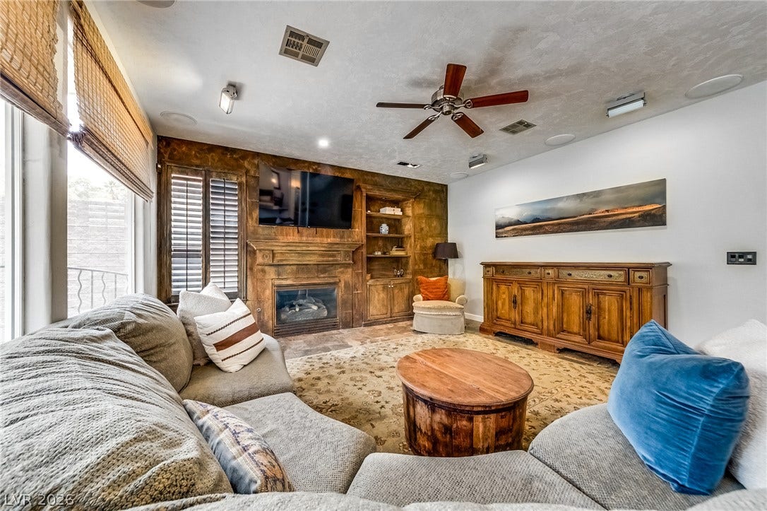 2393 Stansbury Court, Henderson, NV 89052 A welcoming living area featuring a fireplace with built-in shelving, perfect for cozy gatherings.