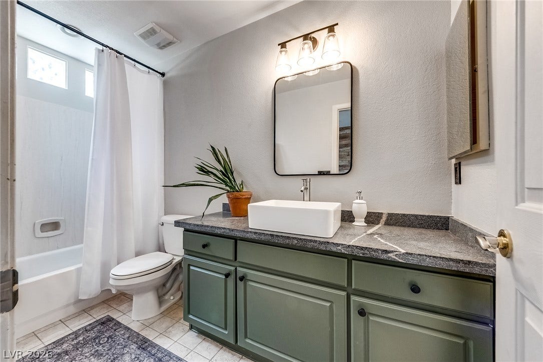 2393 Stansbury Court, Henderson, NV 89052 A well-lit primary bathroom features a sleek rectangular vessel sink and an ample vanity with storage.