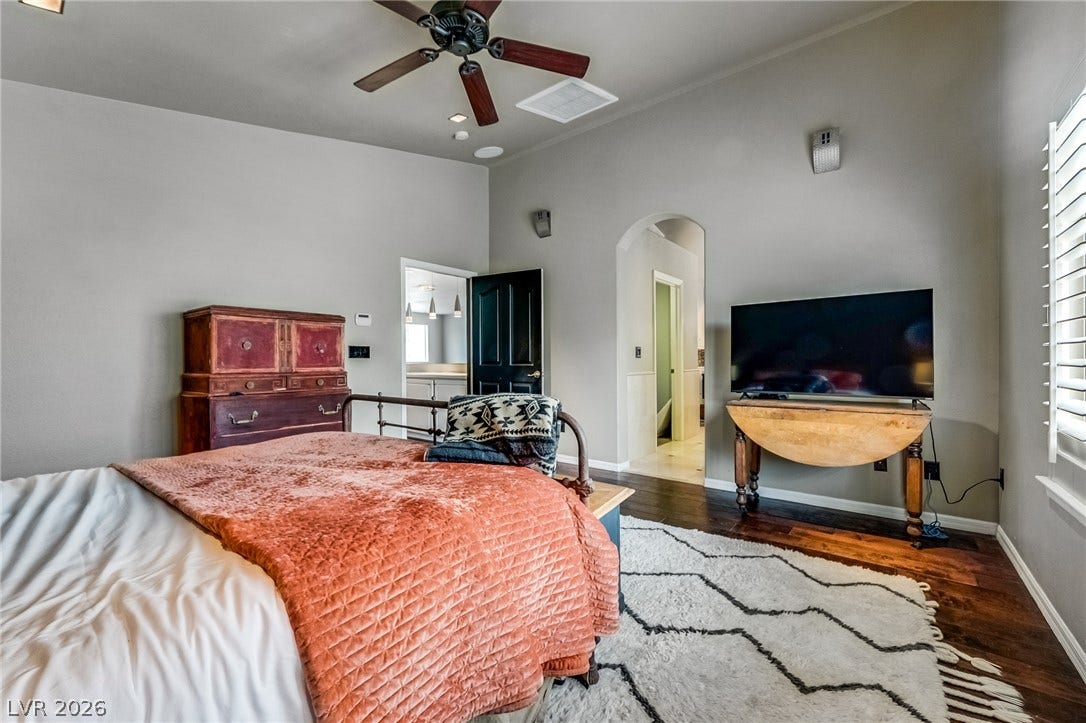 2393 Stansbury Court, Henderson, NV 89052 Hardwood floors and a ceiling fan create a comfortable atmosphere in this well-appointed bedroom.