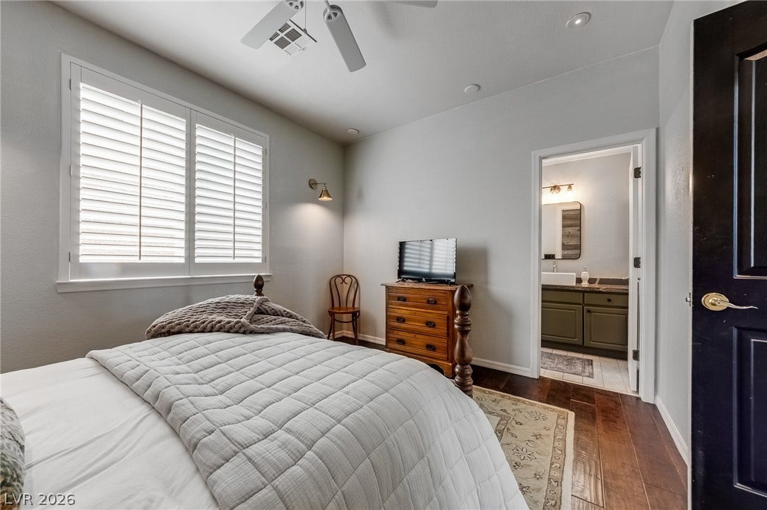 2393 Stansbury Court, Henderson, NV 89052 Comfortable sleeping space featuring hardwood floors and direct access to an en-suite bath.