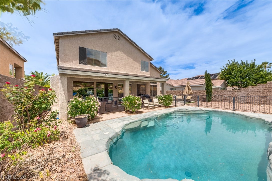 2393 Stansbury Court, Henderson, NV 89052 A private backyard oasis features a glistening pool and a covered patio for ultimate relaxation.