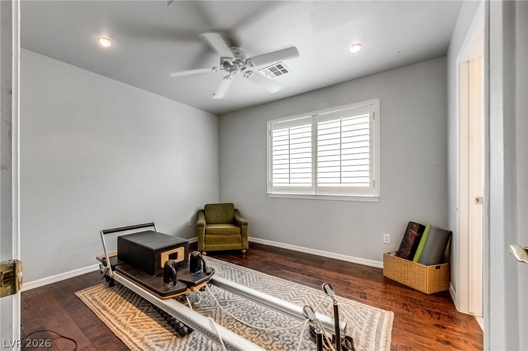 2393 Stansbury Court, Henderson, NV 89052 Rich hardwood floors and shuttered windows create a versatile, well-lit space.