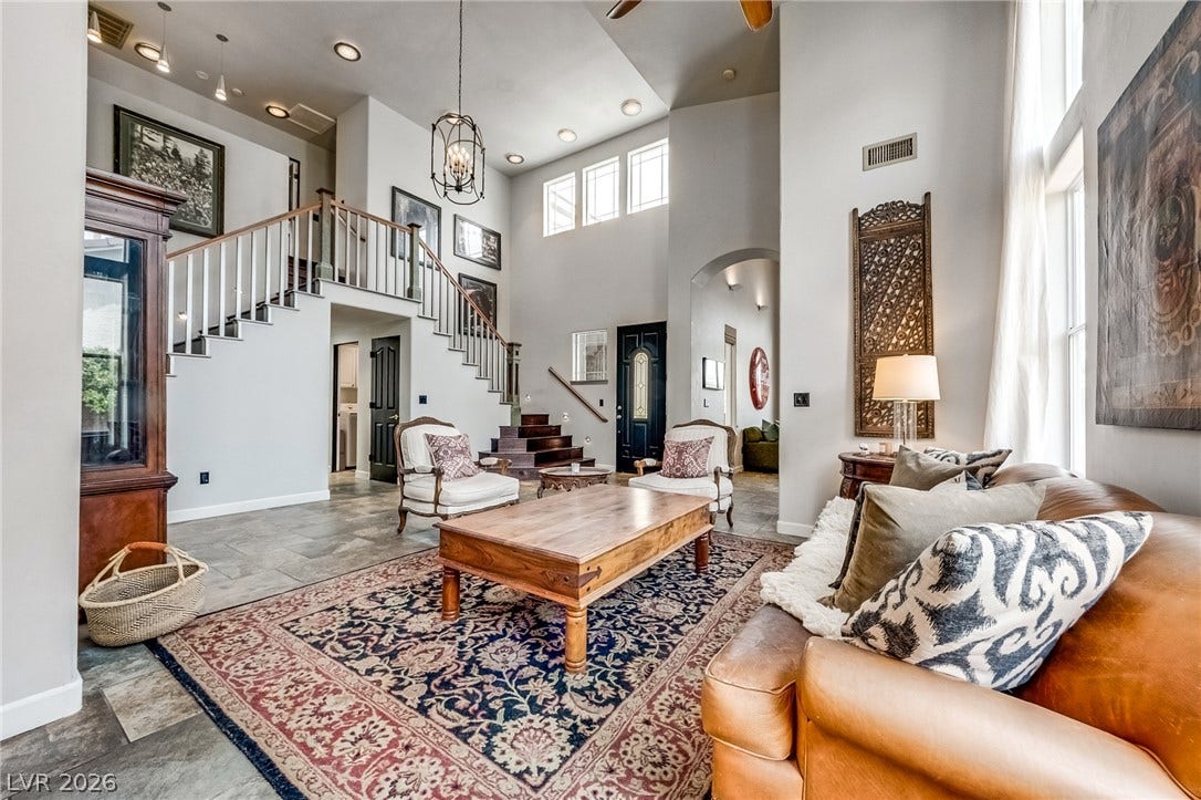 2393 Stansbury Court, Henderson, NV 89052 Grand two-story foyer and living area with a dramatic staircase and a wall of windows.