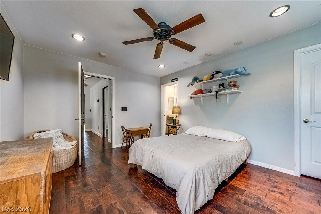 2393 Stansbury Court, Henderson, NV 89052 Rich hardwood floors create a warm, inviting atmosphere in this well-appointed bedroom.