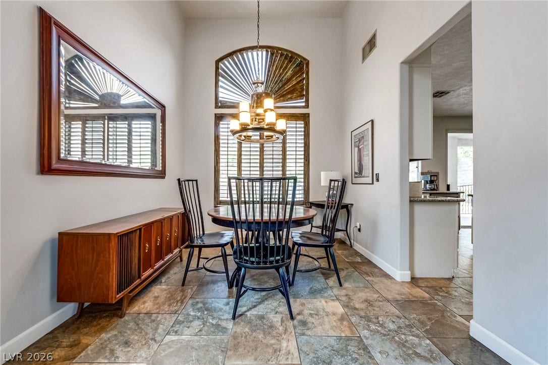 2393 Stansbury Court, Henderson, NV 89052 Arched window with elegant shutters complements the warm flooring, creating a graceful dining space.