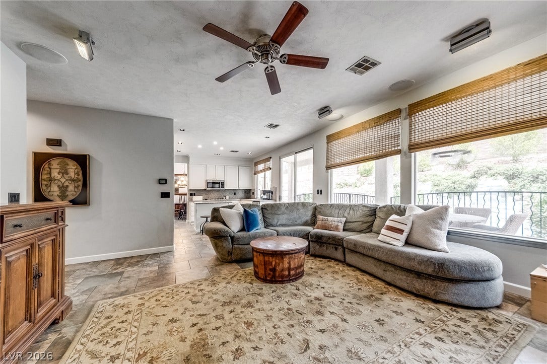 2393 Stansbury Court, Henderson, NV 89052 A comfortable living area with abundant natural light transitions seamlessly into a well-appointed kitchen.