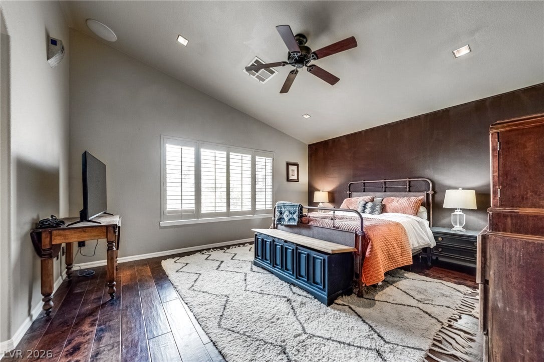 2393 Stansbury Court, Henderson, NV 89052 This spacious primary bedroom offers vaulted ceilings and rich hardwood flooring for refined comfort.
