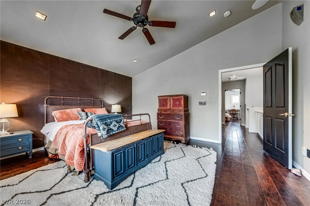 2393 Stansbury Court, Henderson, NV 89052 Step into a generously sized bedroom featuring elegant hardwood flooring and a stylish ceiling fan.