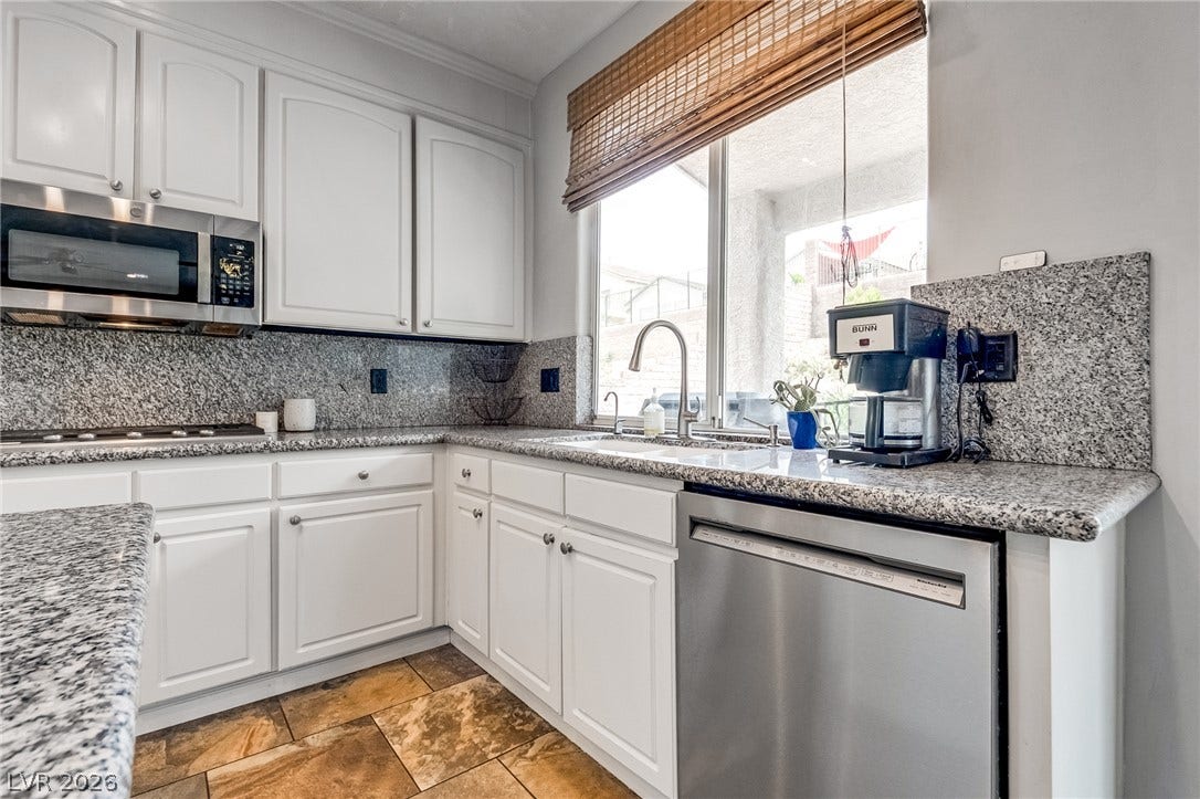 2393 Stansbury Court, Henderson, NV 89052 Culinary delights await in this bright kitchen, featuring granite countertops and ample storage.