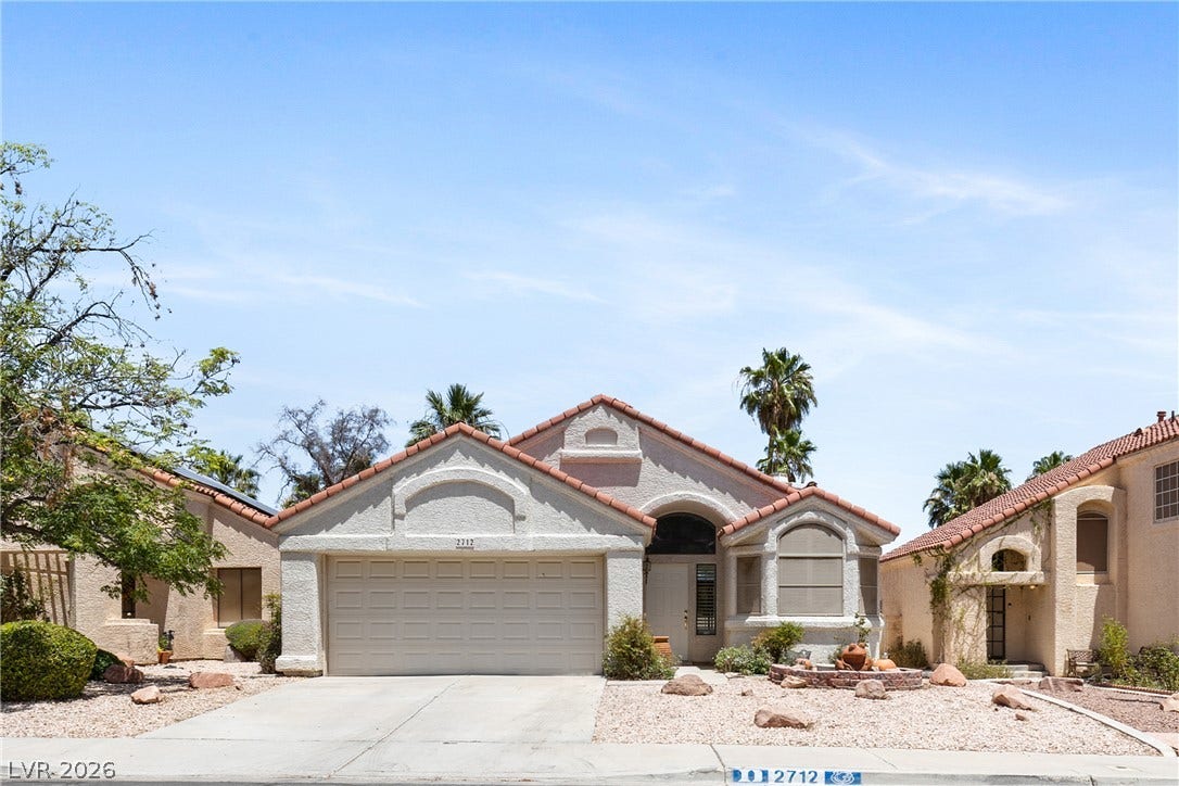 2712 Strathmoor Drive, Henderson, NV 89074 A terracotta-tiled roof crowns this stucco-finished home with an integrated garage and desert-friendly landscaping.
