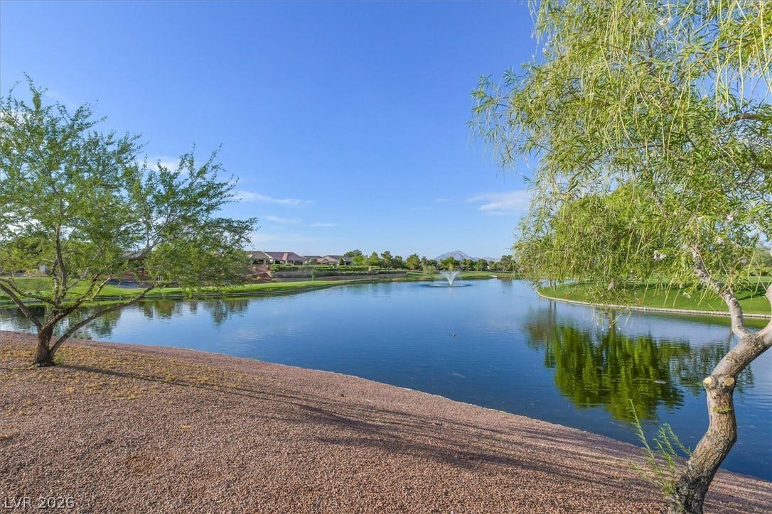 468 Bonnie Brook Place, Henderson, NV 89012 A tranquil lake view, featuring a gentle fountain, offers a serene backdrop to this property.