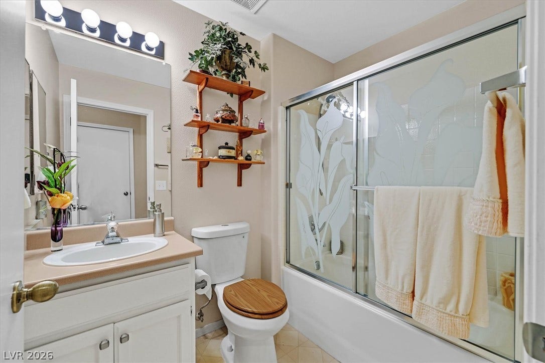 468 Bonnie Brook Place, Henderson, NV 89012 A compact bathroom offers functionality with a vanity, toilet, and a shower-tub combination.