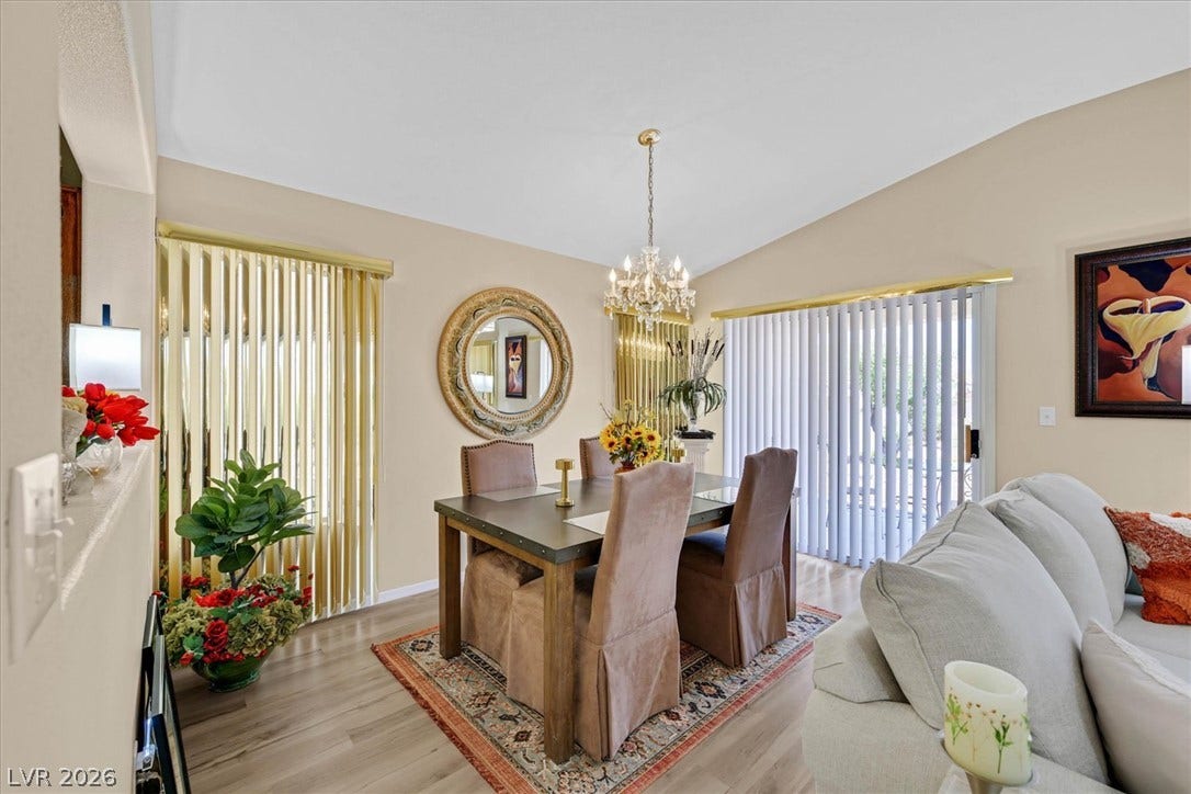 468 Bonnie Brook Place, Henderson, NV 89012 Elegant dining space features high ceilings, an exquisite chandelier, and modern flooring, creating a refined ambiance.