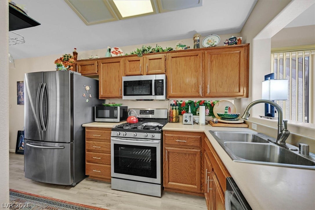468 Bonnie Brook Place, Henderson, NV 89012 This well-appointed kitchen features warm wooden cabinetry, stainless steel appliances, and a dual-basin sink.