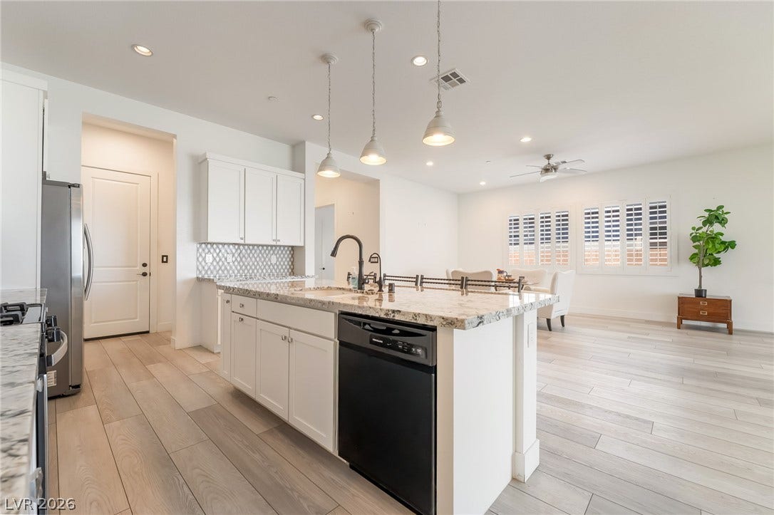 330 Meadow Brush Place, Henderson, NV 89011 A pristine culinary space boasts an island with a breakfast bar, seamlessly connecting to an inviting living area.