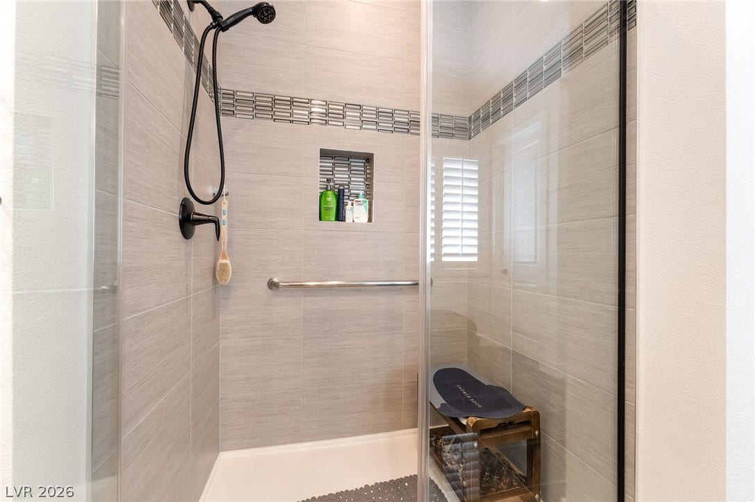 330 Meadow Brush Place, Henderson, NV 89011 A well-appointed shower stall features clear glass enclosure, decorative tile accents, and a convenient built-in niche.
