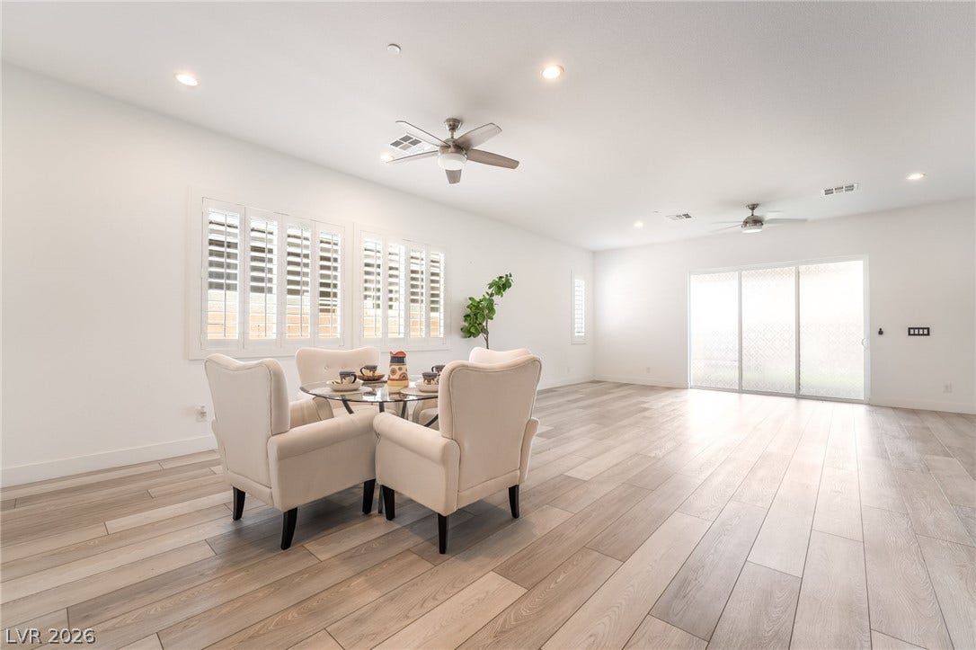 330 Meadow Brush Place, Henderson, NV 89011 An inviting open-concept living area with light wood flooring flows effortlessly towards outdoor access.