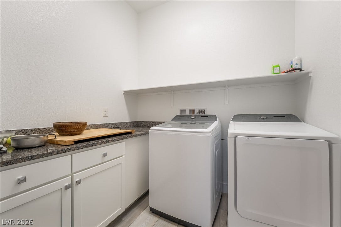 330 Meadow Brush Place, Henderson, NV 89011 Functional laundry space featuring modern appliances and a practical countertop with storage.