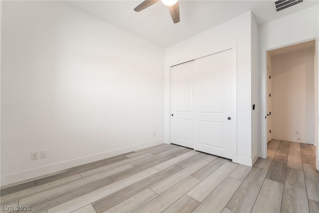 330 Meadow Brush Place, Henderson, NV 89011 Minimalist living space offers modern wood-look tile flooring and a discreet closet, ready for your personal touch.