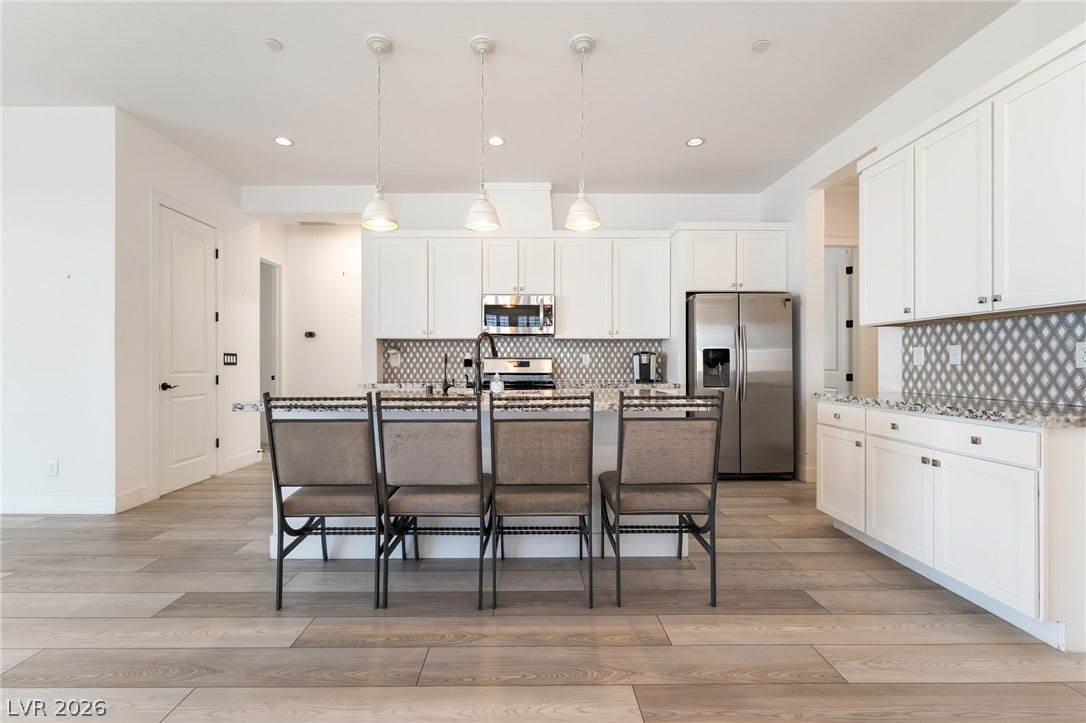 330 Meadow Brush Place, Henderson, NV 89011 Clean lines and light wood flooring define this contemporary kitchen with an inviting breakfast bar.