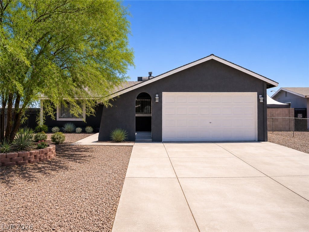 A well-maintained facade with a two-car garage and mature landscaping welcomes you home.