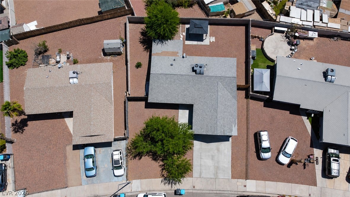 An aerial perspective reveals the residential properties and surrounding xeriscape, featuring paved driveways and fenced yards.