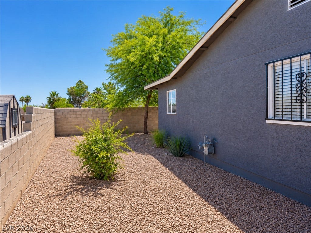 A private, low-maintenance yard features mature landscaping and a practical storage shed.