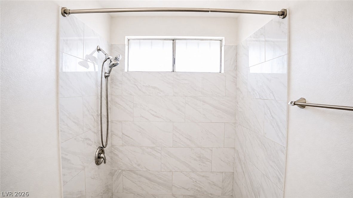 A well-appointed shower with elegant tilework and abundant natural light.