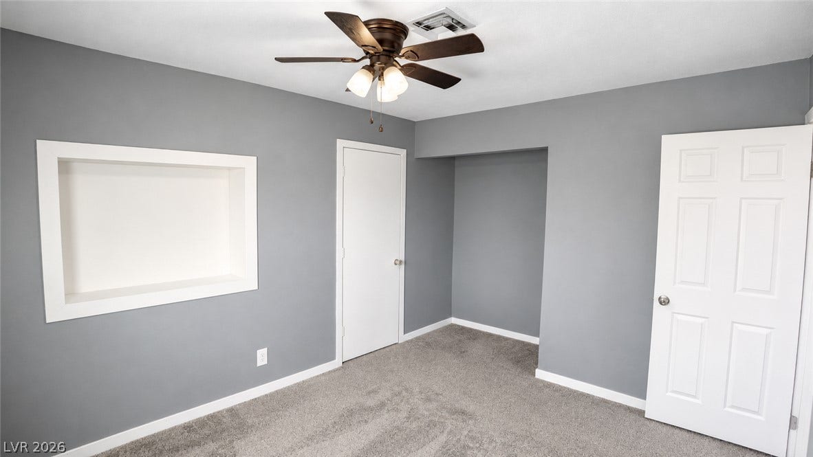 An inviting sleeping space with cozy carpeted floors and a recessed display niche.