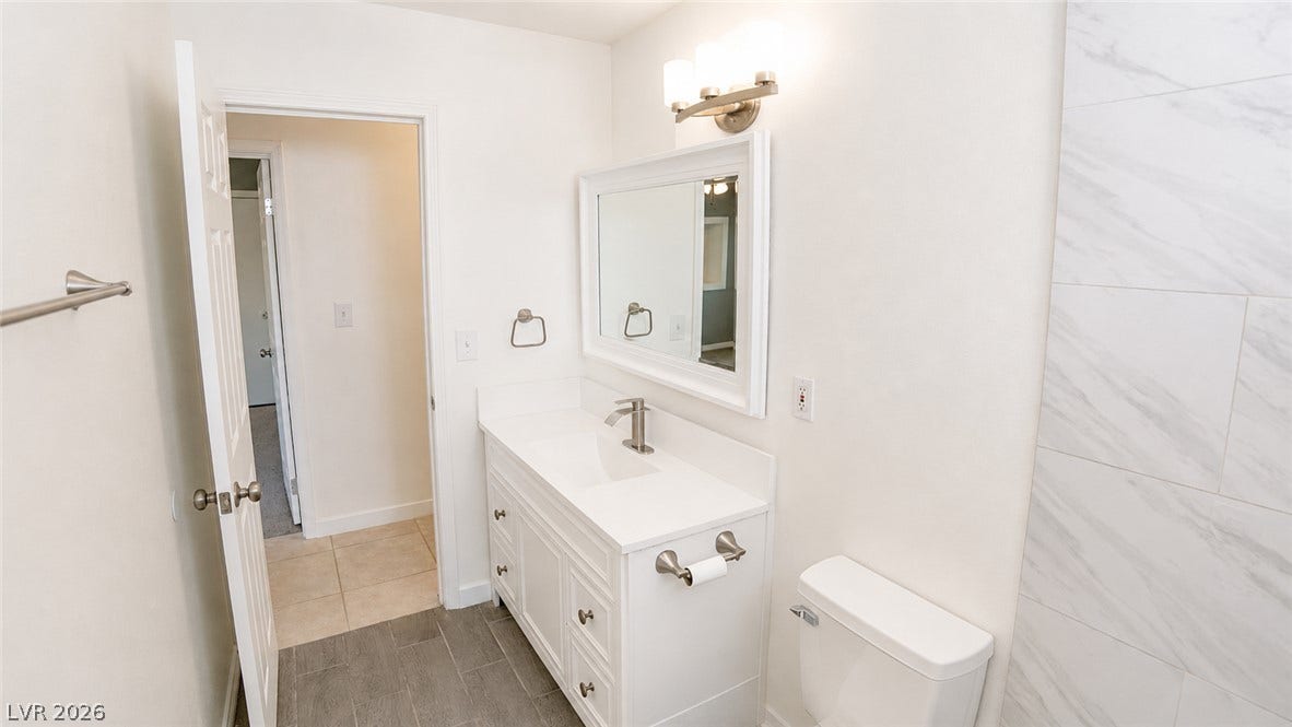 A well-appointed bath features a sleek vanity, modern fixtures, and ample lighting.