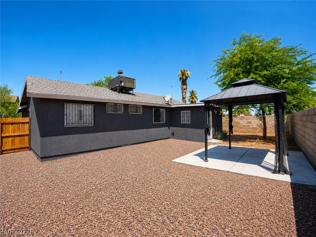 A spacious backyard features a gazebo over a concrete patio, ideal for outdoor gatherings.