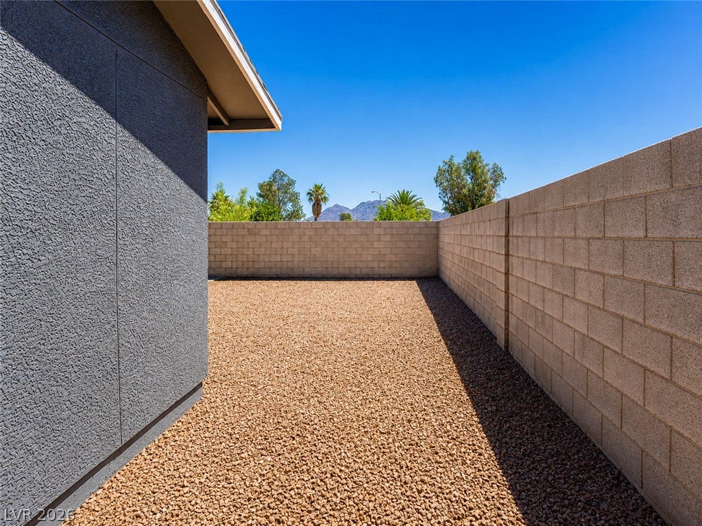 Secure yard featuring robust block fencing and low-maintenance gravel landscaping.
