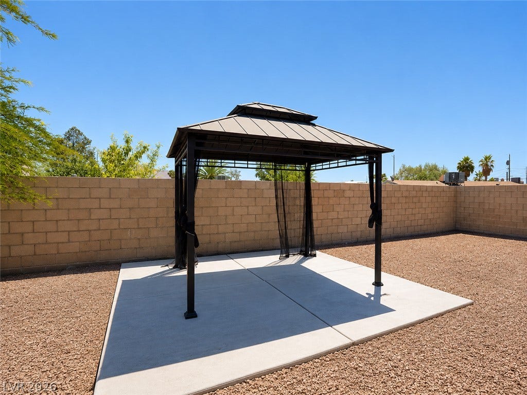 A well-maintained concrete patio and gravel yard create an inviting outdoor space.