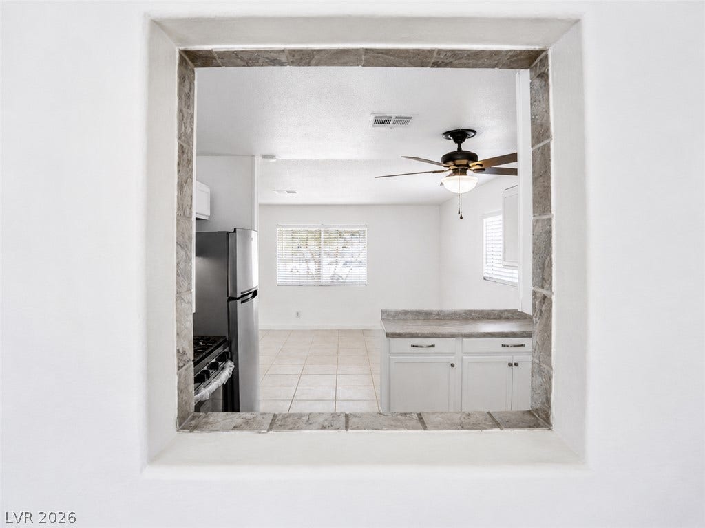 A pass-through window connects the well-appointed kitchen to the adjacent living area.