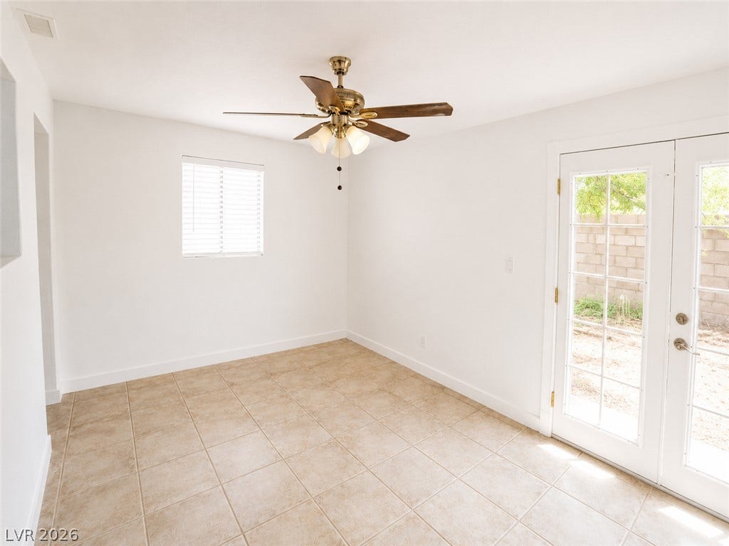 A versatile living space with light-colored tile flooring and direct outdoor access.
