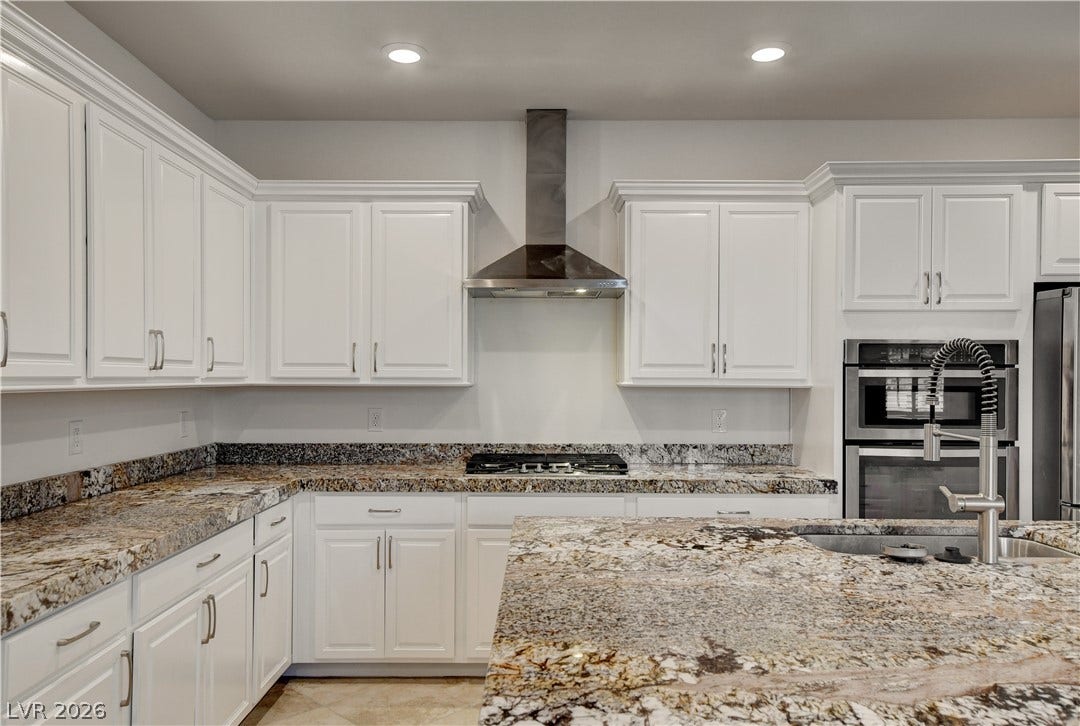 A gourmet kitchen offers rich granite counters and stainless steel appliances.