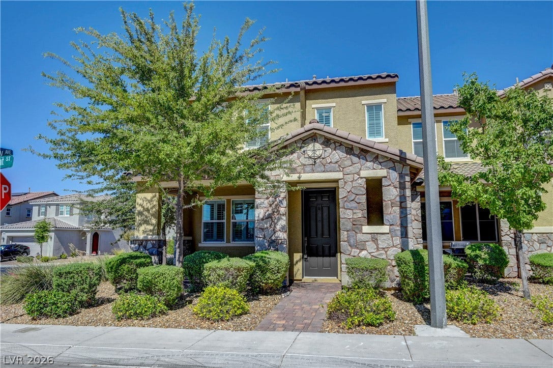A charming facade combines stone accents and lush landscaping, creating inviting curb appeal.
