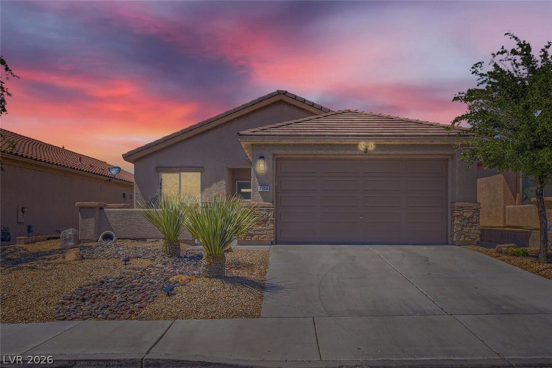 2724 Mintlaw Avenue, Henderson, NV 89044 The home's exterior features a terracotta-tiled roof and a neatly paved driveway set against a vivid sunset backdrop.
