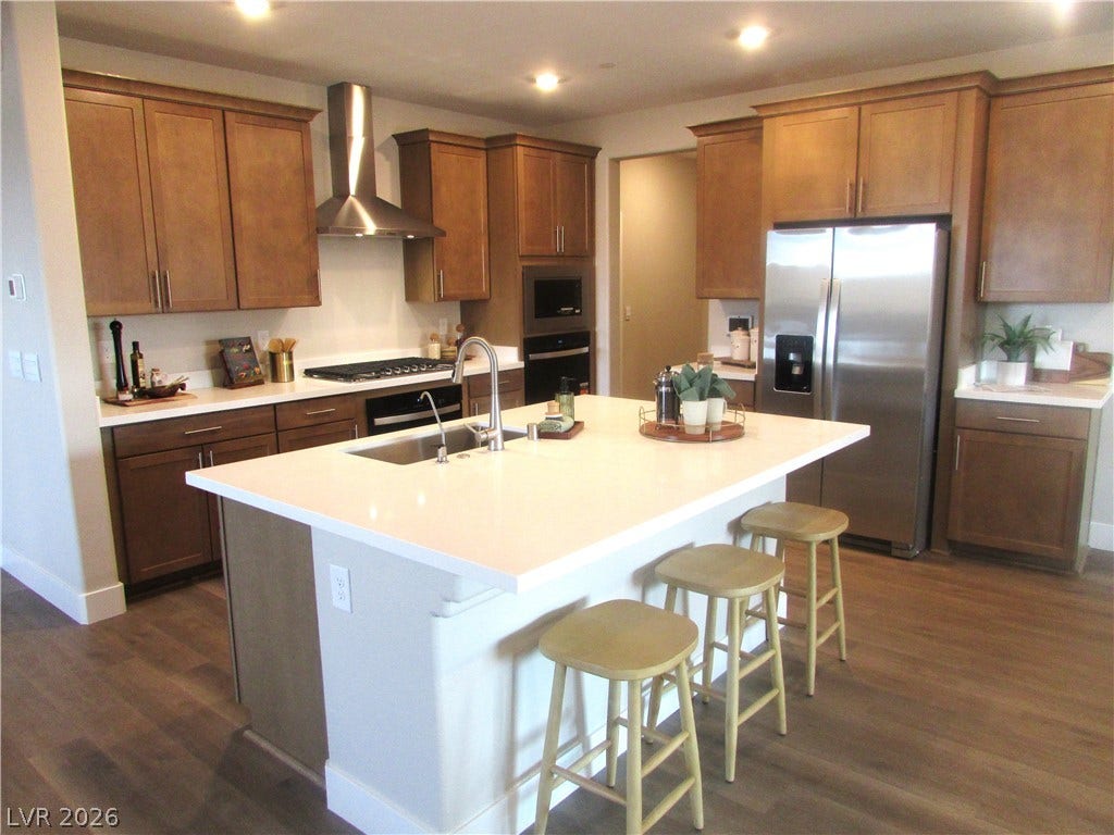 988 Gentle Swan, Henderson, NV 89011 A well-appointed kitchen features ample cabinetry, a generous island with seating, and modern stainless steel appliances.