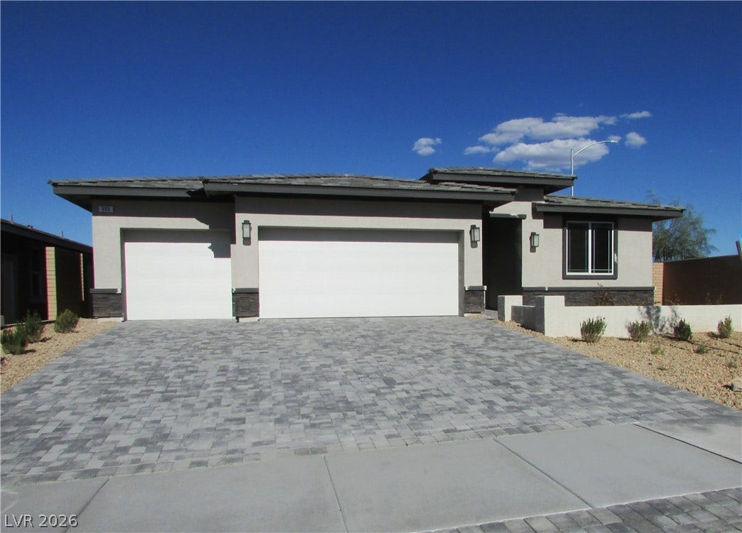 988 Gentle Swan, Henderson, NV 89011 A contemporary desert home with an elegant paver driveway leading to a three-car garage.